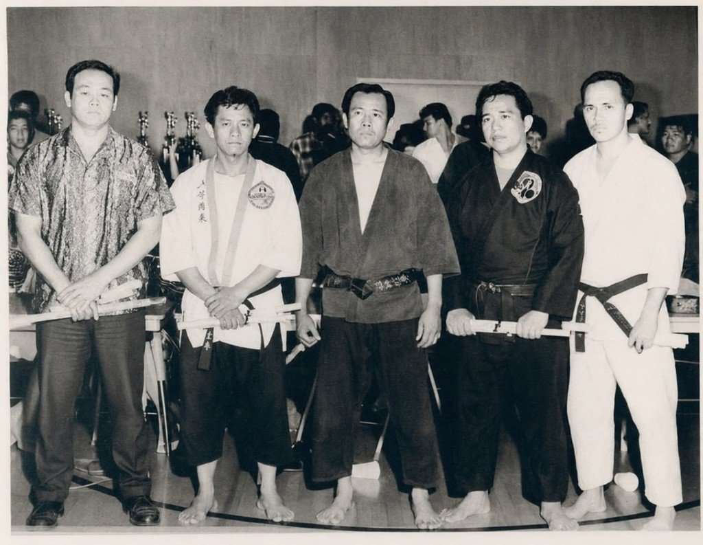 Fotografía histórica de maestros con certificados en ceremonia marcial