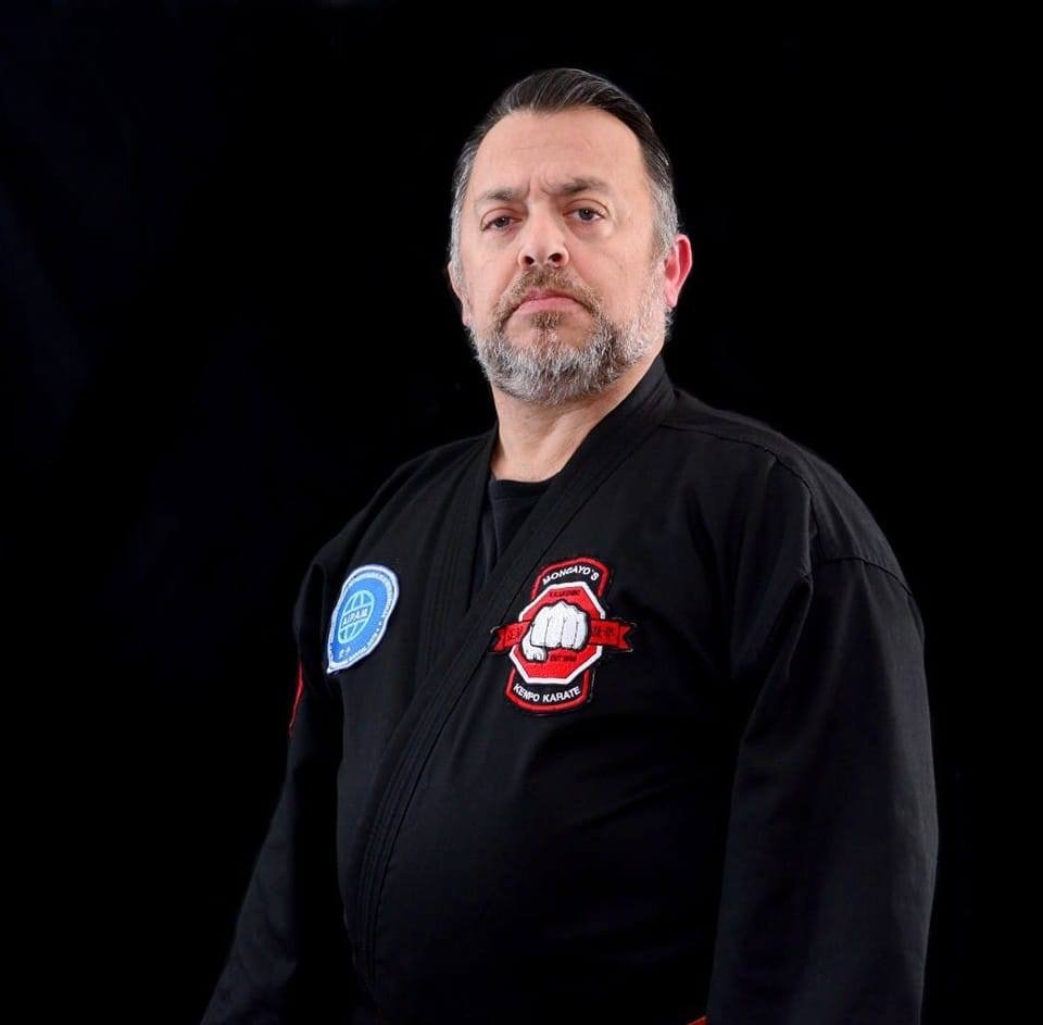 Retrato del Grand Master Gualberto Moncayo con gi negro y emblema Moncayo's Kenpo Karate